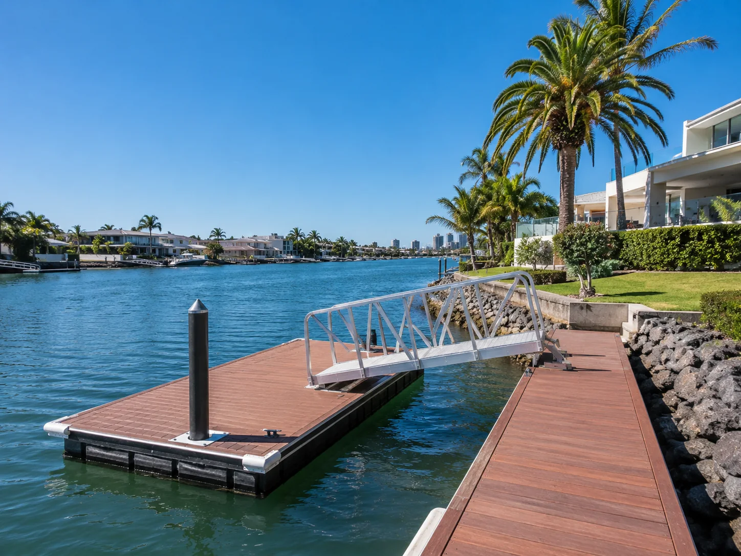 Waterfront inspector reviewing a canal wall beside a modern Gold Coast style home